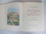 an open book with a picture of a town in the background