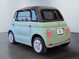 a small green car with a black top parked in a room