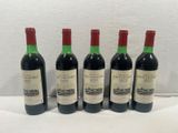 four bottles of wine are lined up on a table