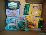 une boîte remplie de nourriture pour chat et un sac de nourriture pour chat