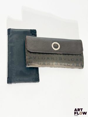 un portefeuille en cuir muni d'un anneau métallique sur le devant et un portefeuille en cuir noir muni d'un anneau métallique au dos