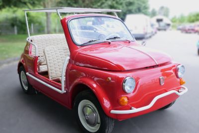a small red car that is parked on the side of the road