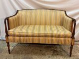 an image of a striped couch sitting on top of a carpeted floor