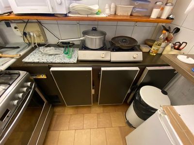 a small kitchen with a stove, sink, and dishwasher