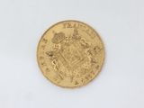 a close up of a gold coin on a white surface