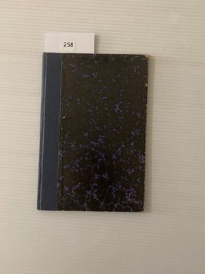 un cahier noir à la couverture bleue posé sur une table blanche