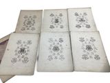four old books with drawings on them sitting on top of each other