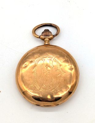 une montre de poche en or sur une surface blanche
