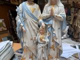une statue représentant un homme et une femme tenant un enfant dans leurs bras