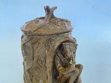 une image représentant une figurine en céramique d'un ours dans un tronc d'arbre