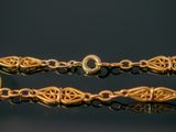 a close up of a gold bracelet on a black surface
