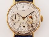 a gold watch with roman numerals on a blue strap