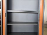 a metal cabinet with shelves in the middle of a room