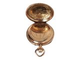 a gold pocket watch hanging on a white wall