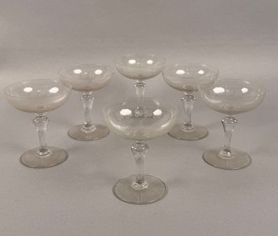 several empty wine glasses are arranged in a circle on a white surface
