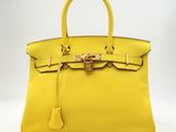 un sac à main en cuir jaune sur fond blanc
