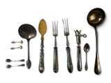 many spoons, forks, and spoon spoons laid out on a white surface