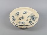 an old blue and white bowl sitting on top of a table