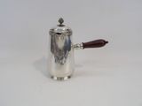 an antique silver coffee pot with a wooden handle on a white surface