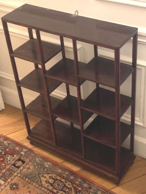 bookshelf in the corner of a room with a rug on the floor