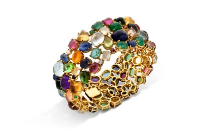gros plan d'une bague en or avec des pierres multicolores