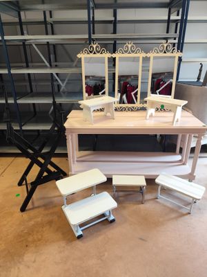 une table avec un miroir et des tabourets dans une pièce