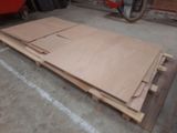 a pile of unfinished plywood on the floor in a garage