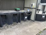 trois poubelles noires placées les unes à côté des autres