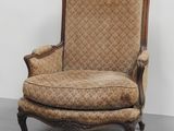 une chaise à l'ancienne dont le dossier est recouvert d'un tissu à motifs floraux