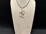a white mannequin with a silver cross on it