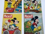 three mickey comics are on display on a table