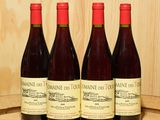 trois bouteilles de vin sont posées sur un tonneau en bois muni d'un bouchon en liège