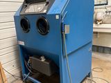 an image of a blue machine is sitting in a garage