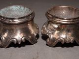 two silver pots sitting on a table next to each other