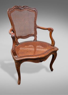 une chaise en bois avec un dossier et une assise en rotin