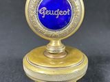 a close up of a small blue and gold object on a black surface