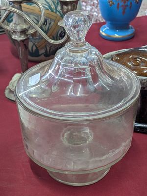 un récipient en verre muni d'un couvercle, posé sur une table