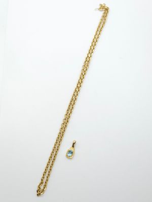 a gold necklace with a turquoise stone and a gold chain