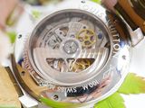 a close up of a watch on a table with leaves