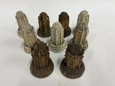 cinq petites statues de tailles et de formes différentes posées sur une surface blanche