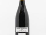 une bouteille de vin posée sur une table blanche
