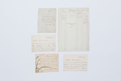 plusieurs feuilles de papier sur lesquelles sont inscrits des caractères, posées sur une surface blanche