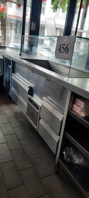des tables et des chaises dans un restaurant doté d'une grande baie vitrée et d'une enseigne accrochée au mur