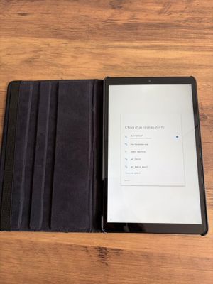 une photo d'une tablette posée sur une table en bois