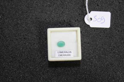 a small white box with a green stone in it