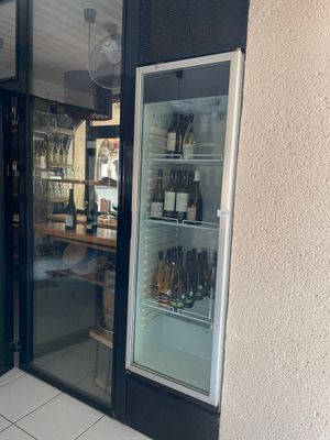 des bouteilles de vin se trouvent dans le réfrigérateur à l'extérieur d'un magasin