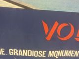 a blue sign that says volk the grandose monument