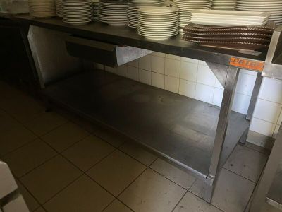 Plusieurs assiettes sont empilées sur une étagère métallique dans une cuisine
