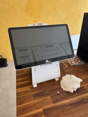two laptops sitting on a desk with papers on it
