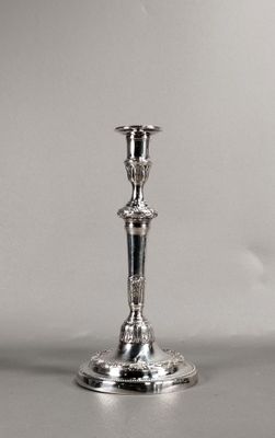 une bougie en argent posée sur une table